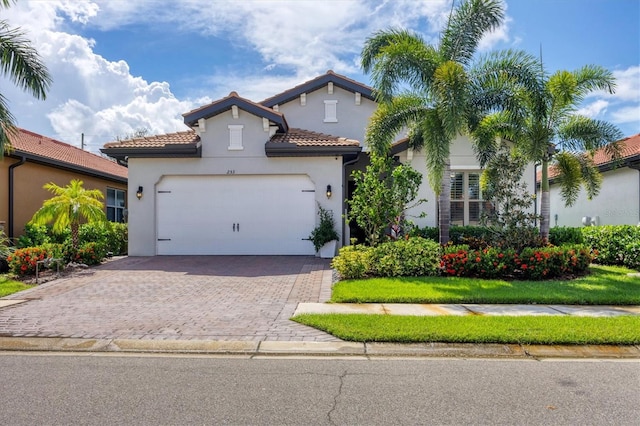 mediterranean / spanish home with a front lawn and a garage