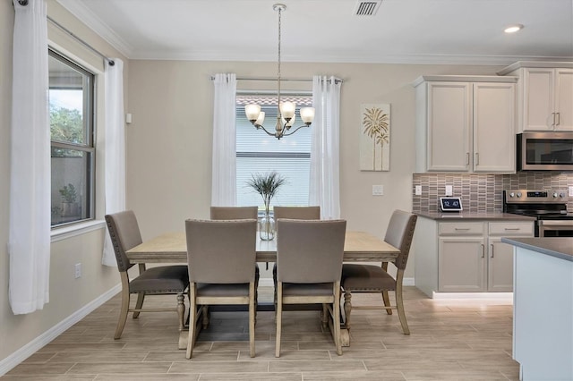 dining room featuring an inviting chandelier, light hardwood / wood-style floors, and ornamental molding