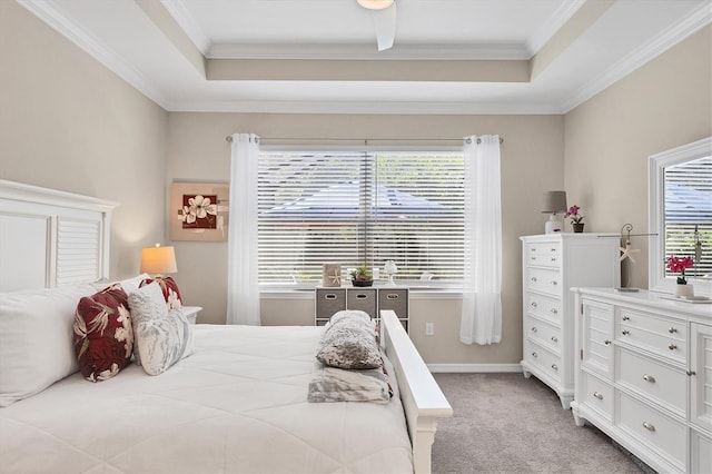 bedroom featuring a raised ceiling, ornamental molding, ceiling fan, and light carpet