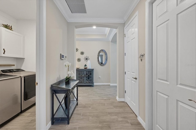 hall featuring washer and clothes dryer, ornamental molding, a tray ceiling, and light hardwood / wood-style floors