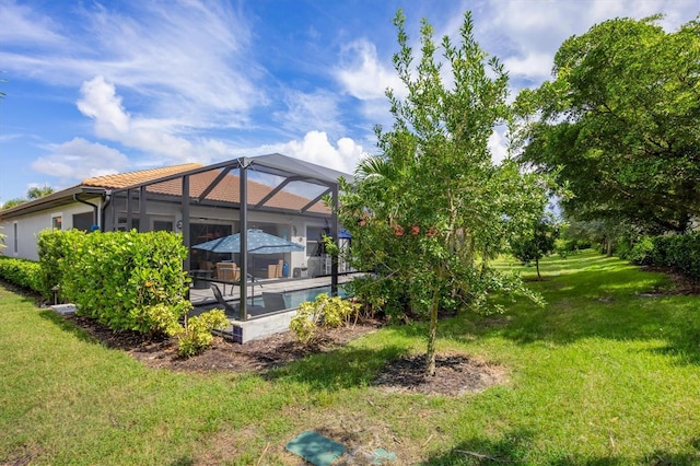 view of yard featuring a lanai, a swimming pool with hot tub, and a patio area