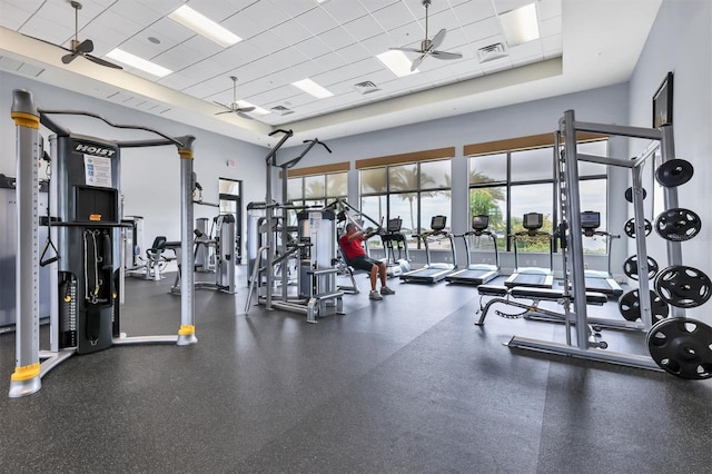 workout area featuring ceiling fan and a paneled ceiling