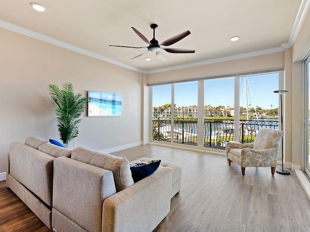 living room featuring ceiling fan, hardwood / wood-style flooring, crown molding, and a water view