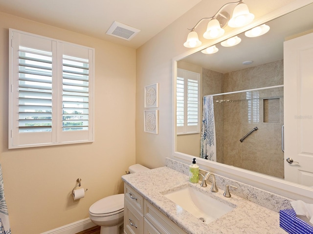 bathroom featuring walk in shower, vanity, and toilet