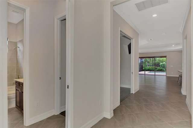 hall featuring crown molding and light tile patterned floors