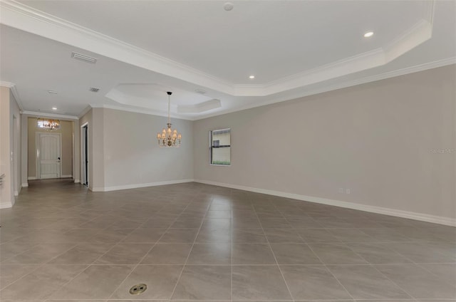 unfurnished room with crown molding, a tray ceiling, tile patterned floors, and a notable chandelier