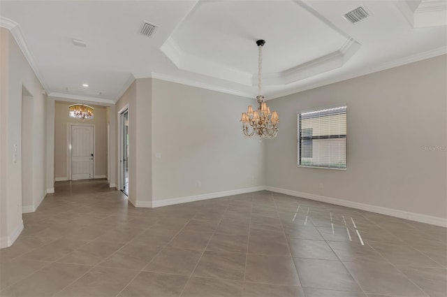 tiled spare room featuring crown molding, a tray ceiling, and a notable chandelier