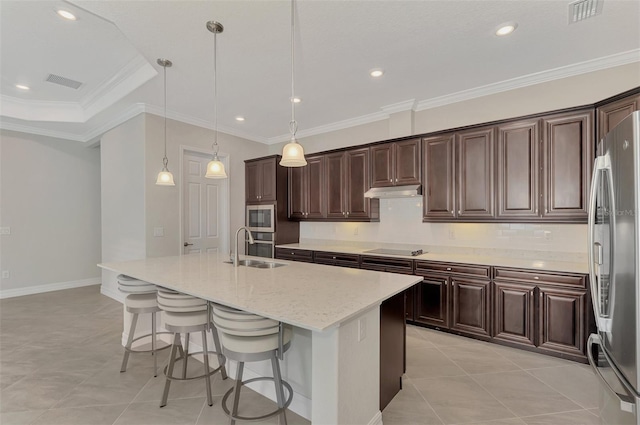 kitchen featuring appliances with stainless steel finishes, an island with sink, decorative light fixtures, ornamental molding, and sink