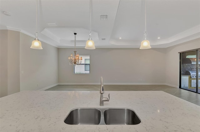 kitchen with ornamental molding, a raised ceiling, hanging light fixtures, and sink