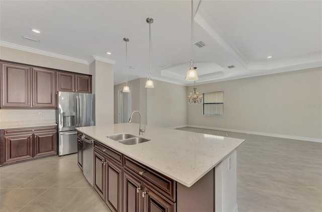 kitchen with hanging light fixtures, an island with sink, light stone counters, stainless steel appliances, and sink