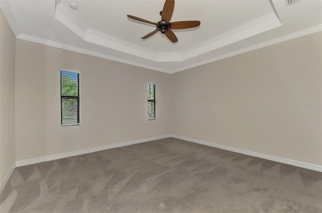 carpeted empty room featuring ceiling fan, a raised ceiling, and crown molding