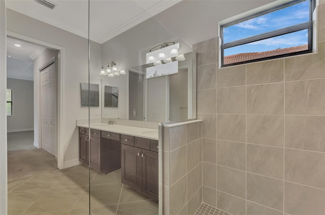 bathroom with tile patterned floors, walk in shower, vanity, and crown molding