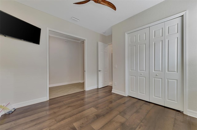 unfurnished bedroom with a closet, ceiling fan, and dark hardwood / wood-style floors