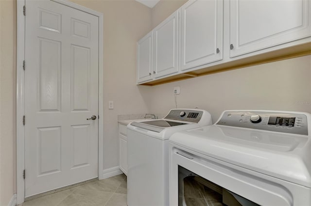 laundry area featuring cabinets, independent washer and dryer, and light tile patterned floors