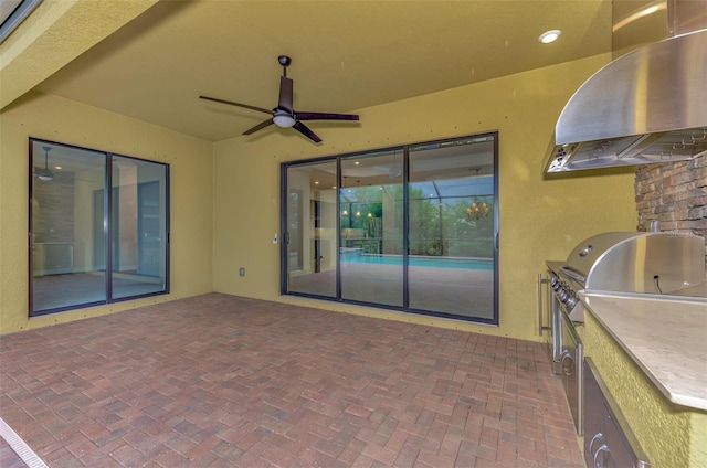 view of patio with area for grilling, ceiling fan, and a grill