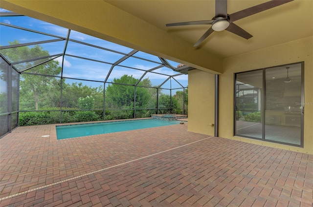 view of pool with ceiling fan, glass enclosure, a patio, and an in ground hot tub