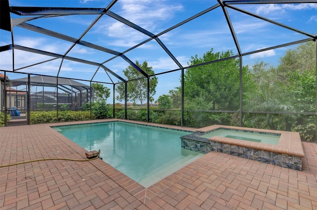 view of swimming pool with a lanai, an in ground hot tub, and a patio area