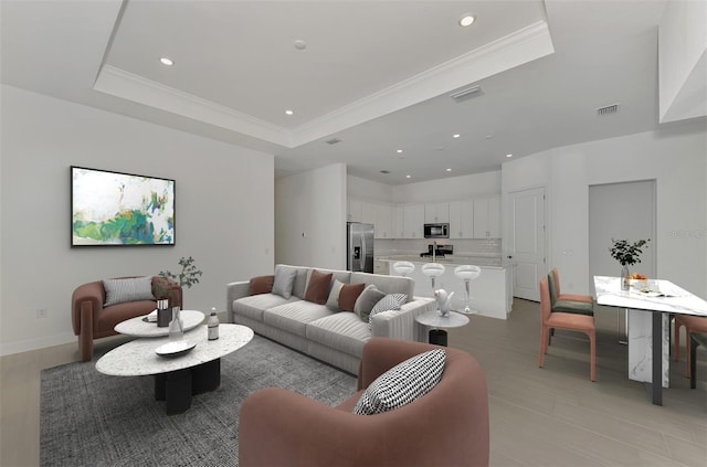 living room with crown molding and a tray ceiling