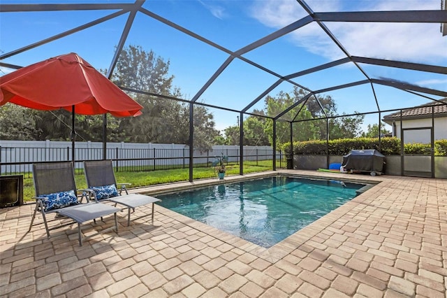 view of pool with a grill, a lawn, a lanai, and a patio area