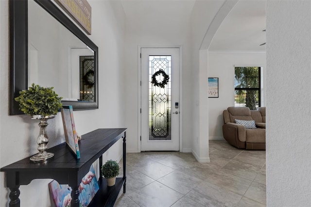 foyer featuring a healthy amount of sunlight and crown molding