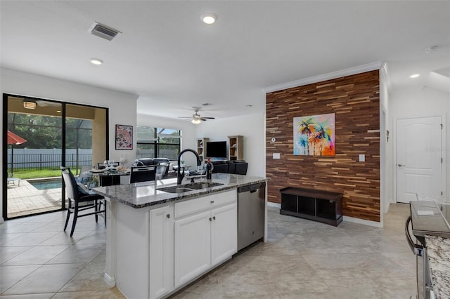 kitchen with white cabinetry, stone countertops, a healthy amount of sunlight, and stainless steel dishwasher