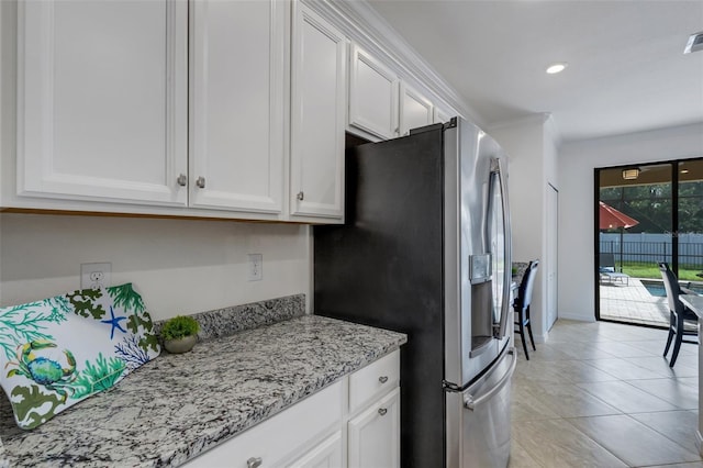 kitchen featuring light tile patterned flooring, light stone countertops, stainless steel fridge with ice dispenser, and white cabinets