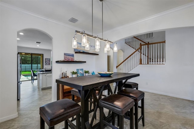 dining room featuring crown molding and light tile patterned floors