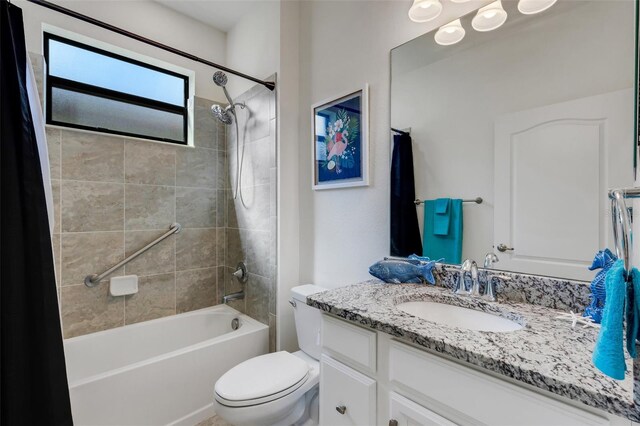 full bathroom with shower / bathtub combination with curtain, vanity, and toilet