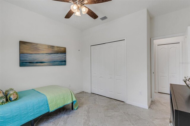 bedroom featuring light tile patterned floors, ceiling fan, and a closet