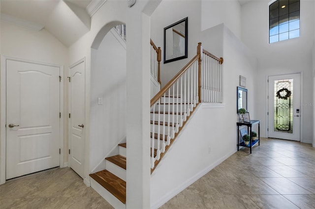 tiled foyer entrance featuring a towering ceiling