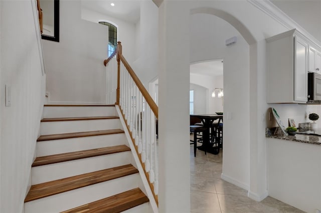 stairway with a healthy amount of sunlight and tile patterned floors