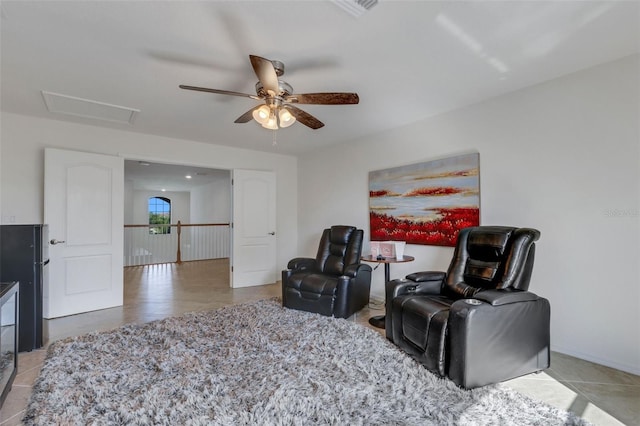 sitting room with ceiling fan and tile patterned flooring