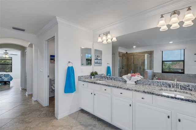 bathroom with ornamental molding, vanity, a shower with shower door, and toilet