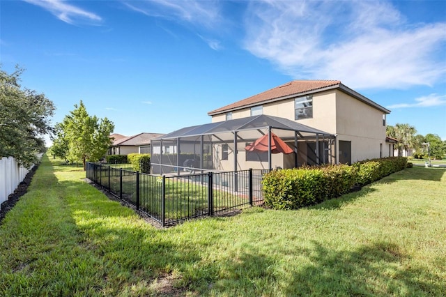 rear view of property with a lanai and a yard