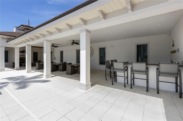 view of patio / terrace with ceiling fan and a bar