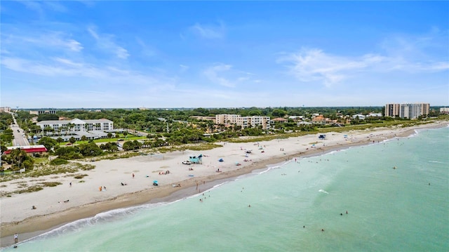 birds eye view of property with a water view and a beach view