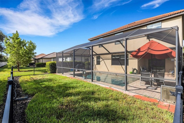 view of yard featuring a fenced in pool, glass enclosure, and a patio area