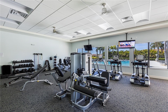 workout area featuring ceiling fan and a drop ceiling