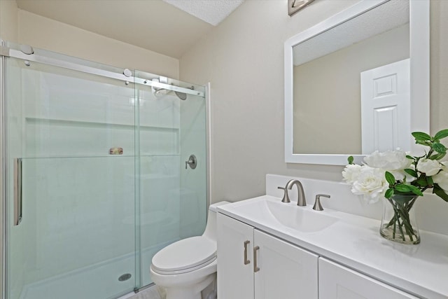 bathroom with a shower with door, vanity, and toilet