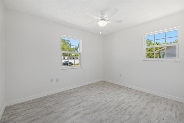 unfurnished room with ceiling fan, a textured ceiling, and light wood-type flooring