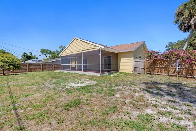 back of house featuring a yard and a sunroom