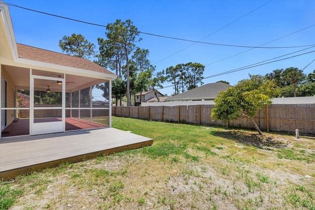 view of yard with ceiling fan, a deck, and a sunroom