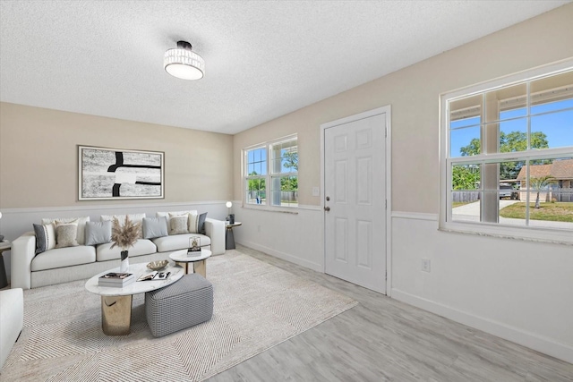 living room featuring light hardwood / wood-style floors and a textured ceiling