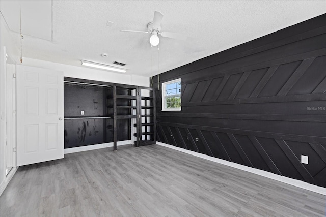 spare room with hardwood / wood-style flooring, ceiling fan, and a textured ceiling