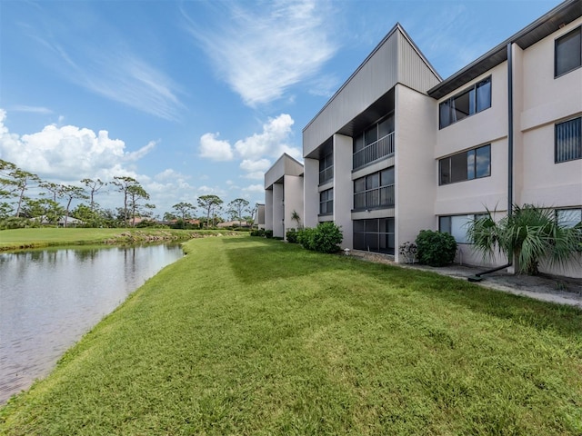 view of home's community with a water view and a yard