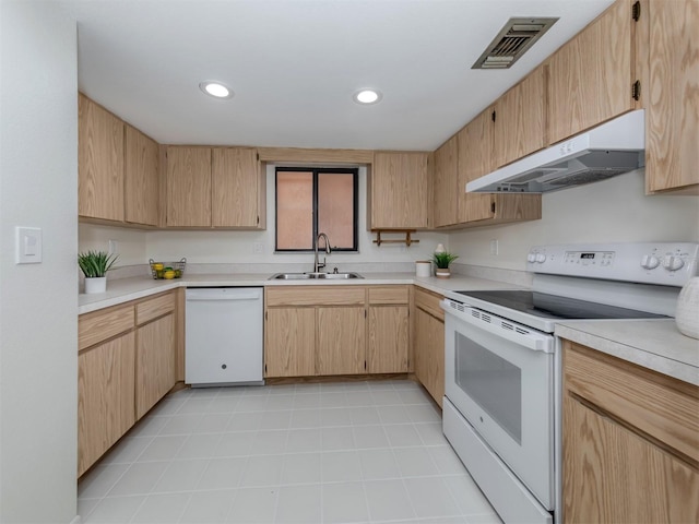 kitchen with white appliances, light brown cabinets, and sink