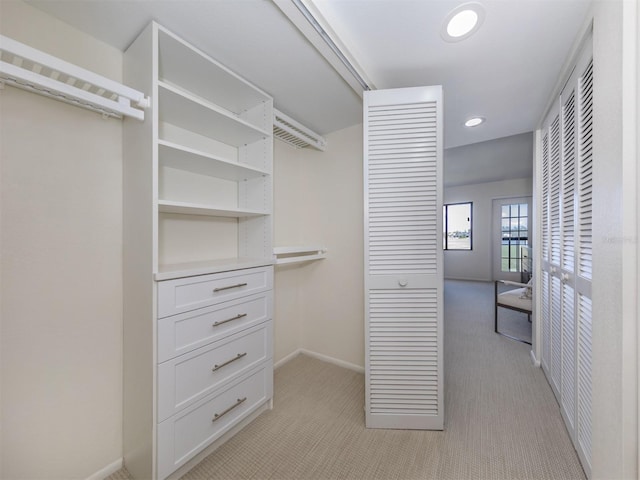 walk in closet featuring light carpet