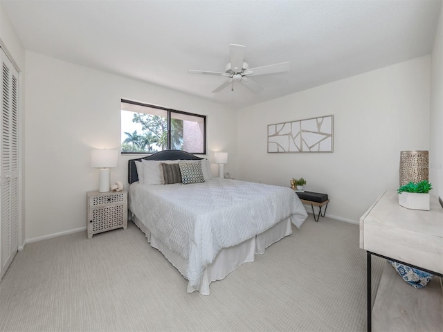 bedroom featuring ceiling fan, light colored carpet, and a closet