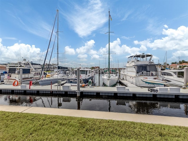 view of dock featuring a lawn and a water view