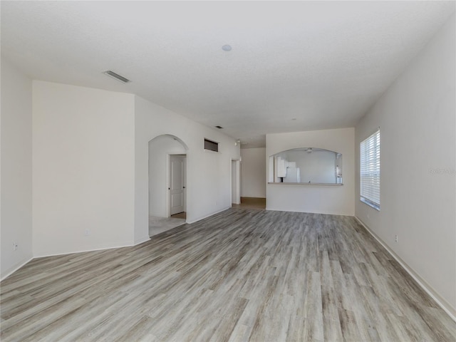 unfurnished living room with light hardwood / wood-style floors and a textured ceiling